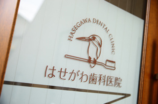 入口ははせがわ歯科医院のロゴ「かわせみ」がお出迎え